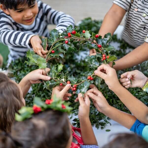 Children handle a holly wreath.